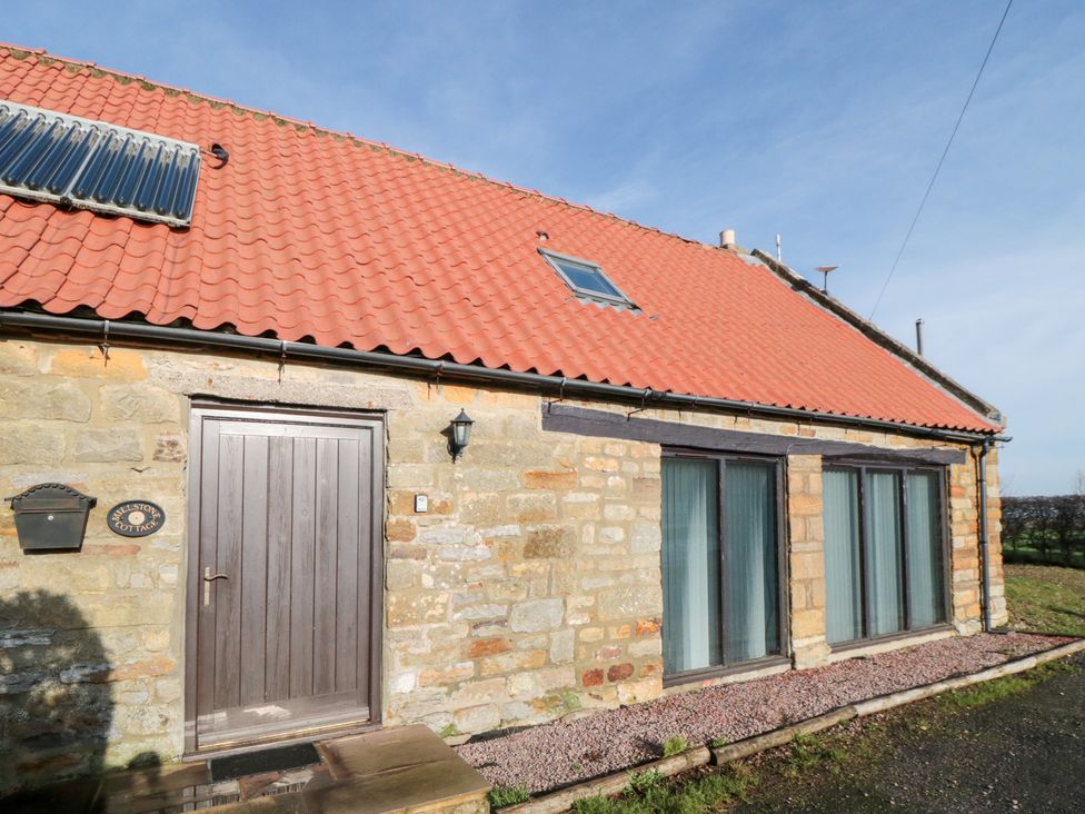 Exterior view of Millstone Cottage with stone wall and red roof in Sneaton Thorpe near Whitby
