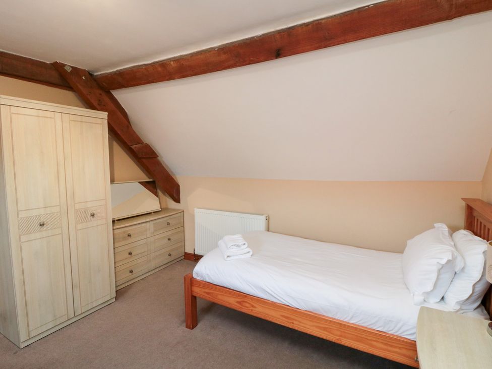 A bedroom with a bed and wardrobe at Millstone Cottage Sneaton Thorpe near Whitby