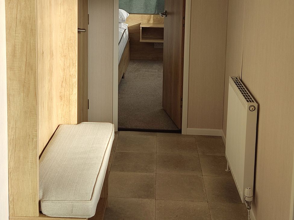 A hallway with a bench and radiator at Harbour View in Poole