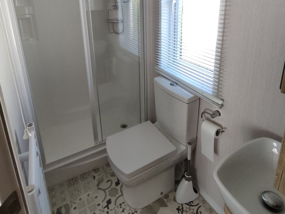 A bathroom with a shower, toilet, and sink at Harbour View in Poole