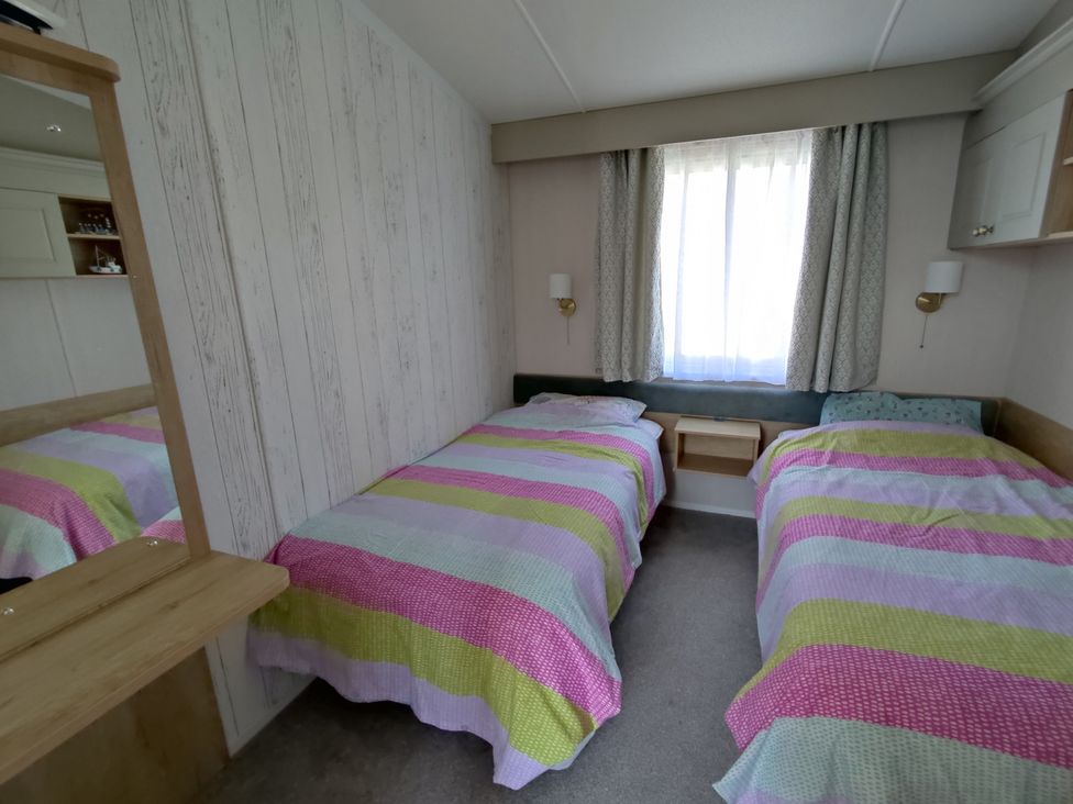 A bedroom with two beds and a window at Harbour View in Poole
