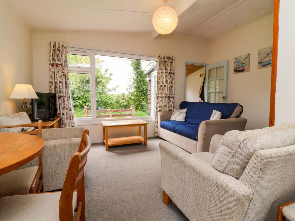A living room with a sofa and table at Sea Breeze in Welcombe near Morwenstow
