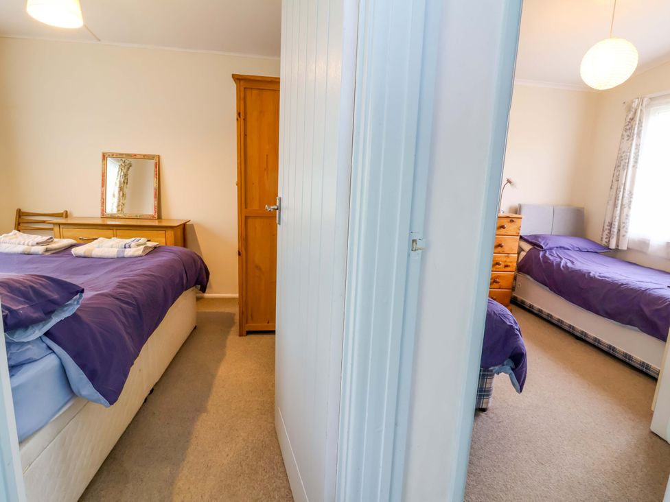 A bedroom with beds and furniture at Sea Breeze in Welcombe near Morwenstow