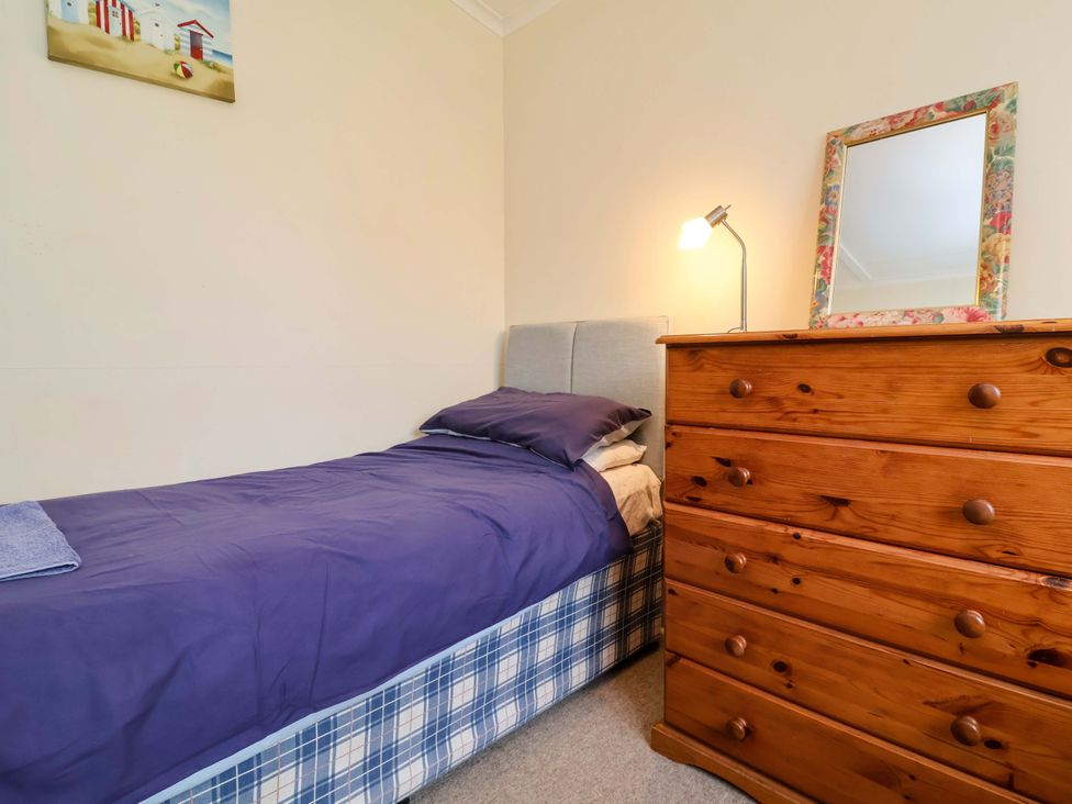 A bedroom with a bed and dresser at Sea Breeze in Welcombe near Morwenstow