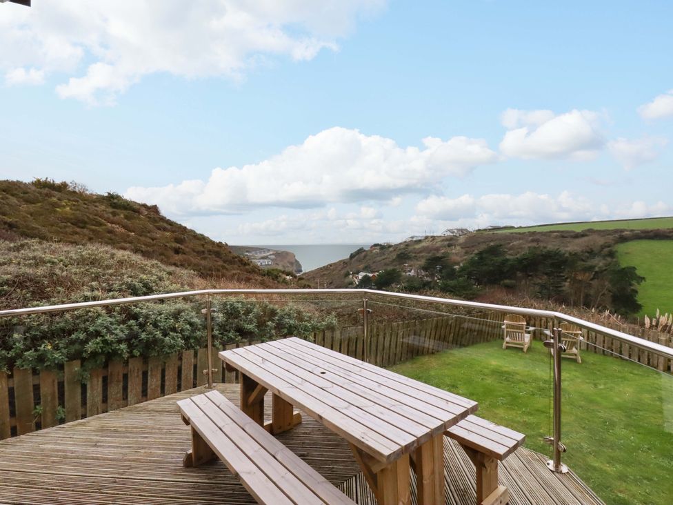A wooden table with benches overlooking hills and sea at Poldreth in Truro