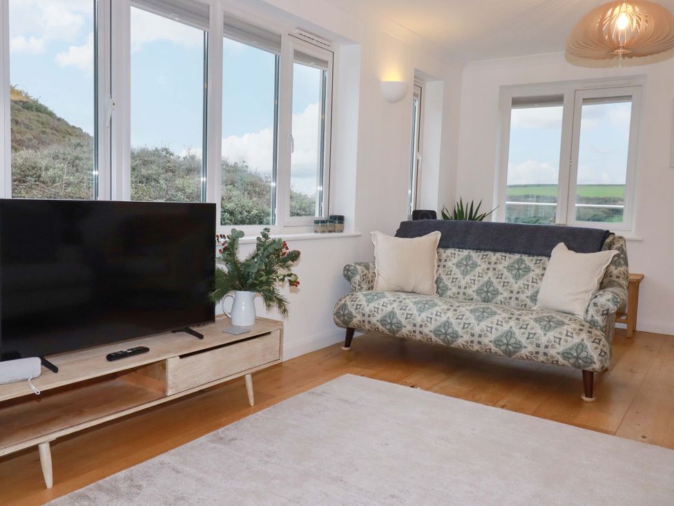 A living room with a television and sofa at Poldreth in Truro