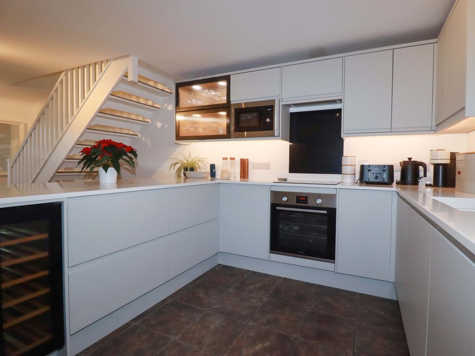 A kitchen with modern appliances and cabinets at Poldreth Truro
