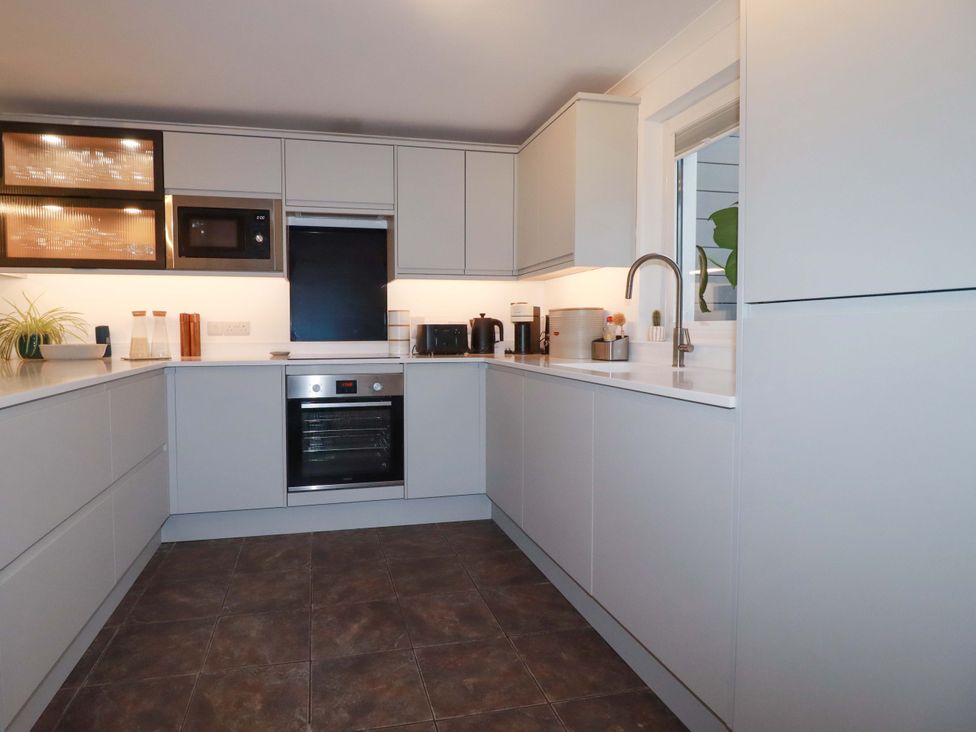 A kitchen with modern appliances and storage at Poldreth in Truro
