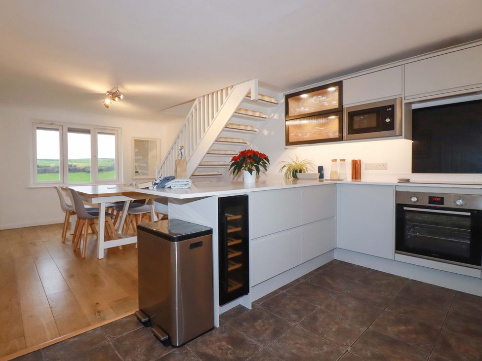 A kitchen with a dining table and chairs at Poldreth in Truro