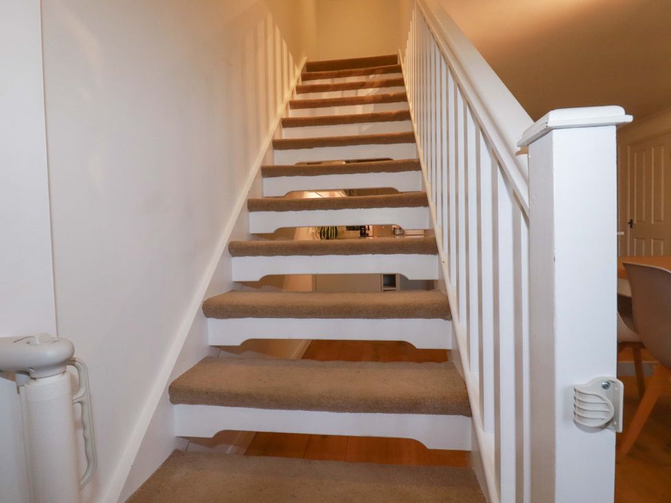 A staircase with carpet and a handrail at Poldreth in Truro