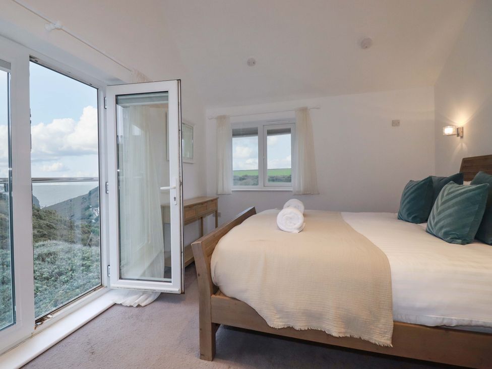 A bedroom with a bed and a table at Poldreth in Truro