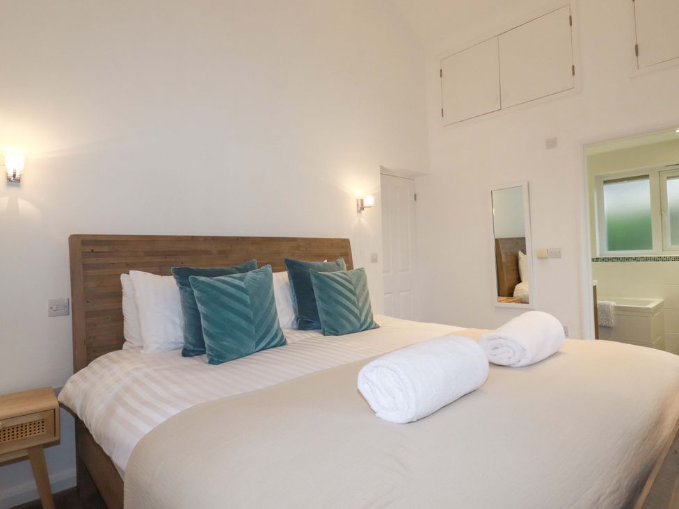 A bedroom with a bed and bathroom access at Poldreth in Truro