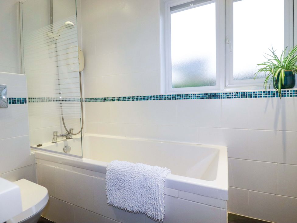 A bathroom with a bathtub, shower and a plant at Poldreth in Truro
