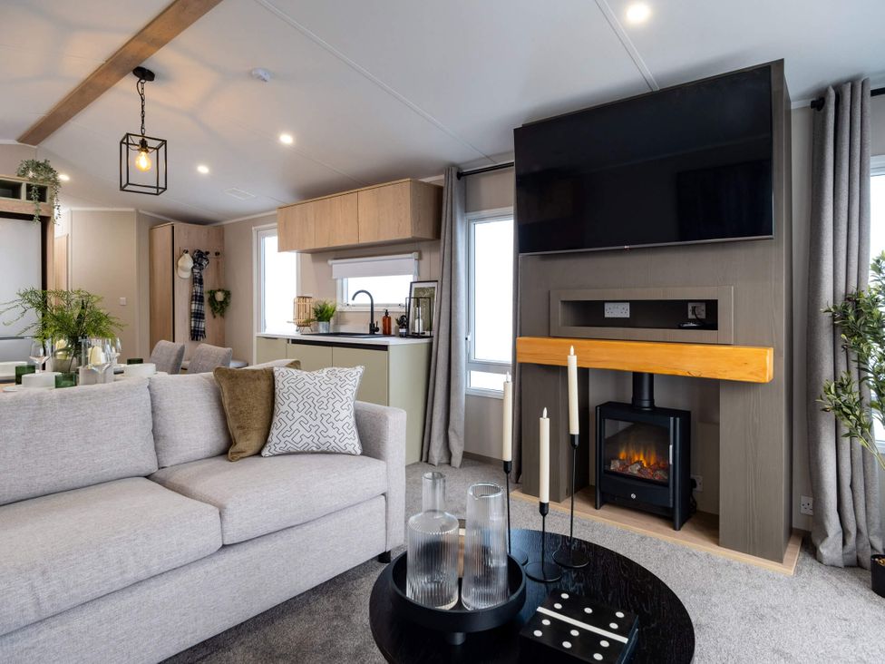 A living room with a sofa and television at Arlington 40 x 14 Three Bed in Northwich