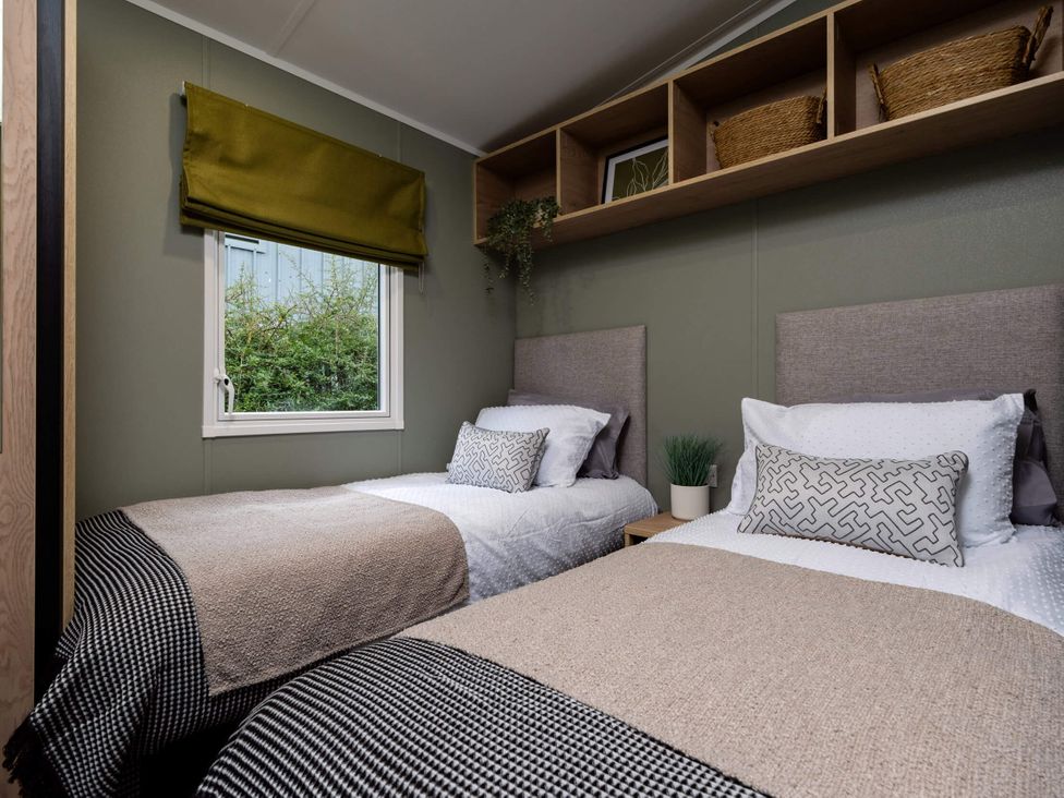 A bedroom with two beds and a shelf at Arlington 40 x 14 Three Bed in Northwich