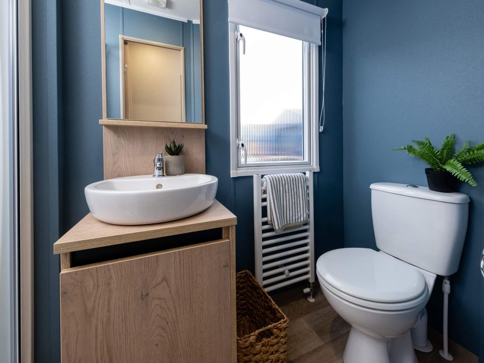 A bathroom with a sink, toilet, and mirror at Arlington 40 x 14 Three Bed in Northwich