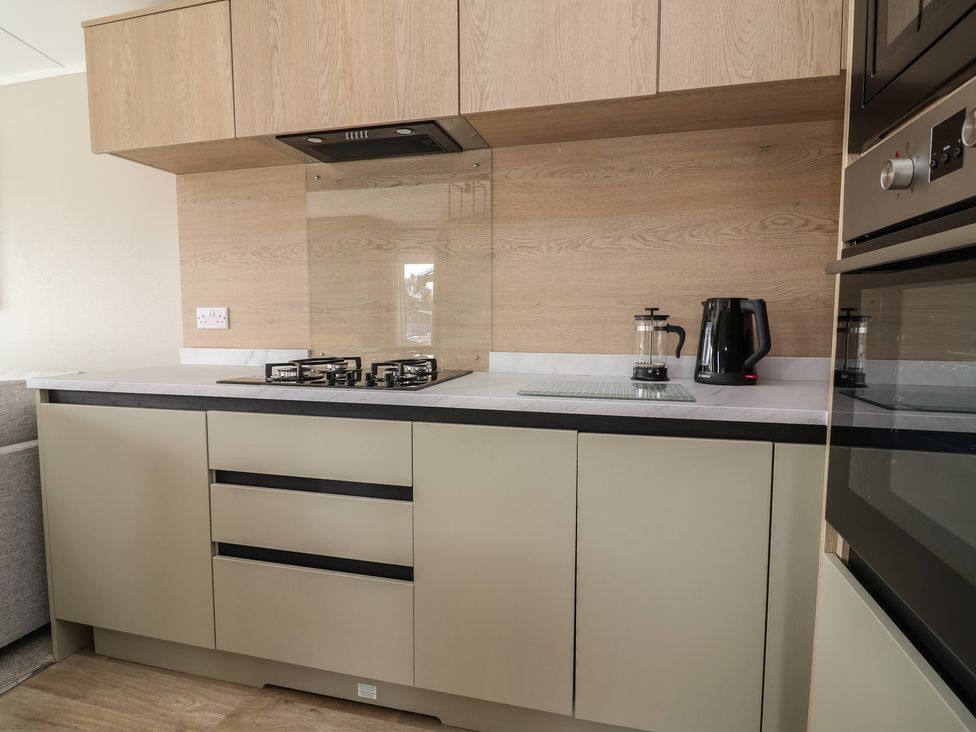 A kitchen with gas stove, coffee maker, and kettle at No.6 - The Pines, Delamere