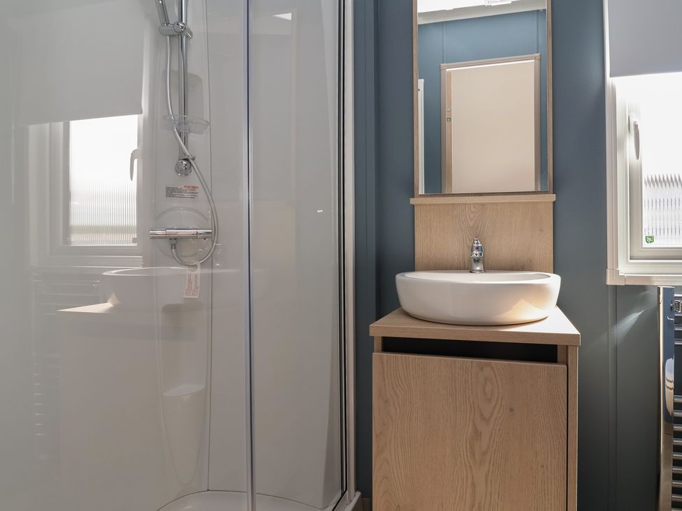 A bathroom with a shower, sink, and mirror at No.6 - The Pines, Delamere