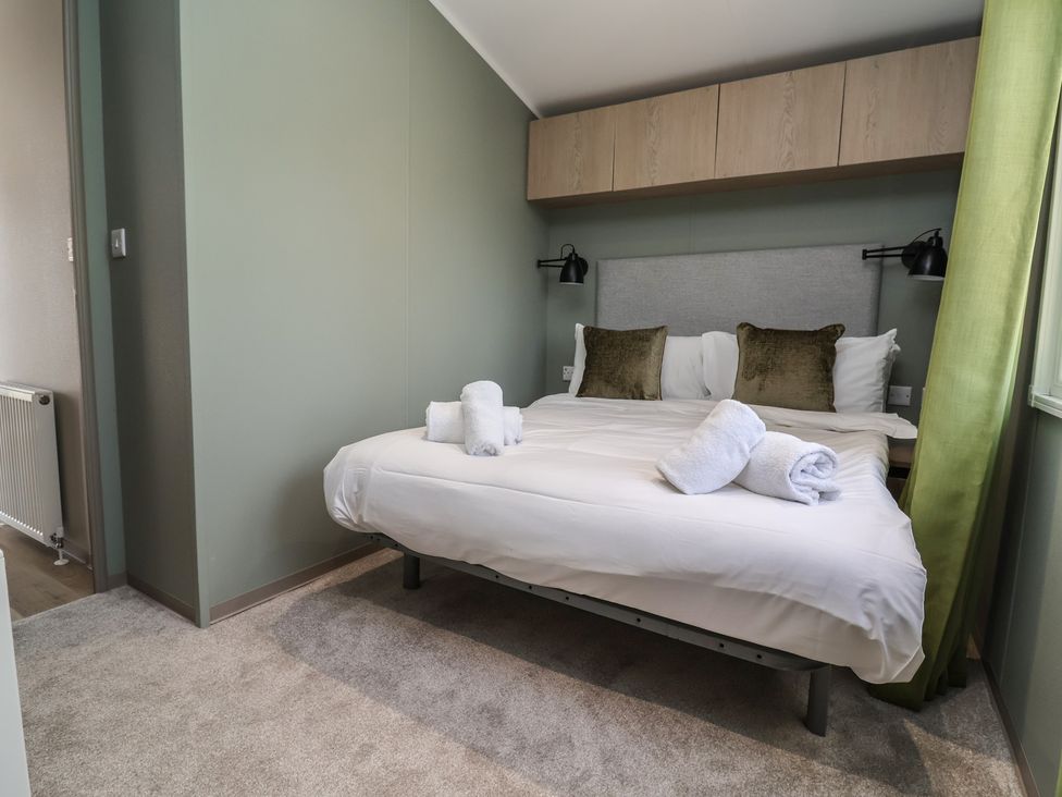 A bedroom with a bed and towels at No.6 - The Pines in Delamere
