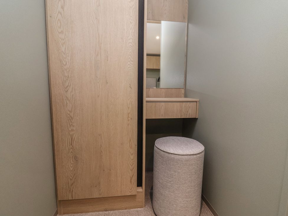 A dressing room with a mirror and stool at No.6 - The Pines in Delamere