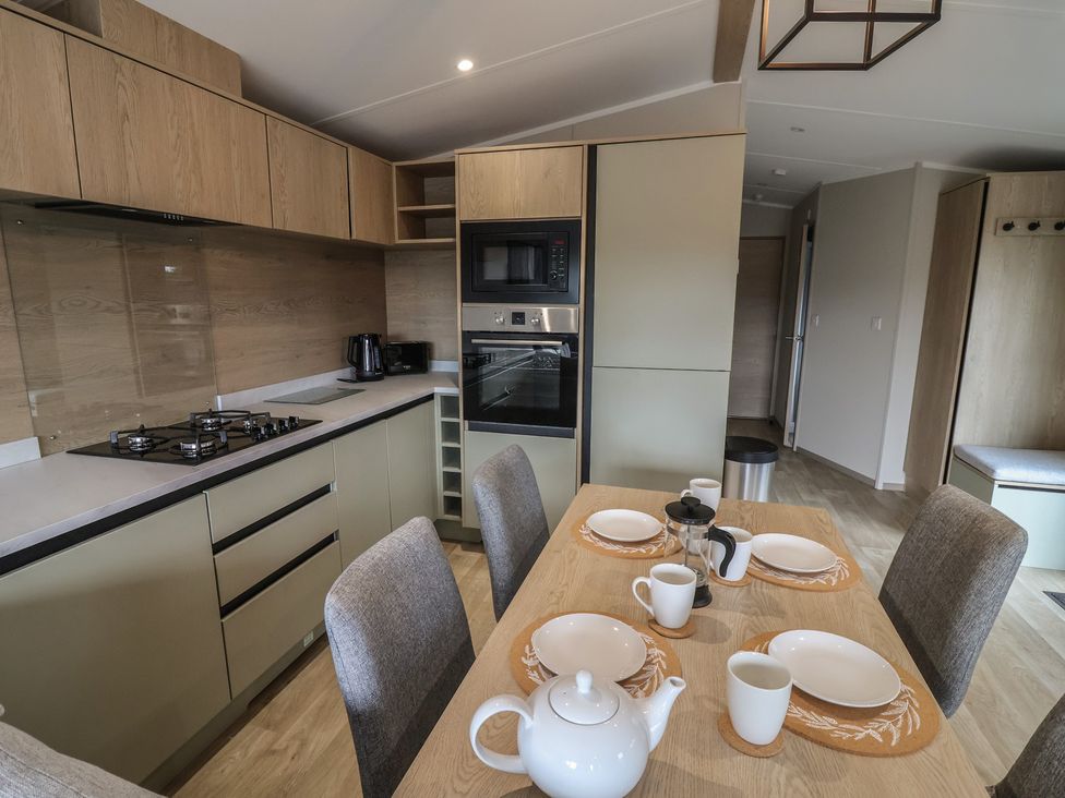A kitchen with a dining table set for a meal at The Pines 3 Bedrooms in Delamere