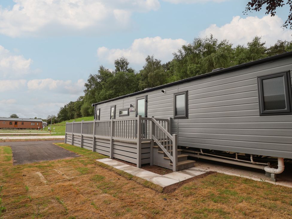 A mobile home with a deck and steps at The Pines 3 Bedrooms Delamere