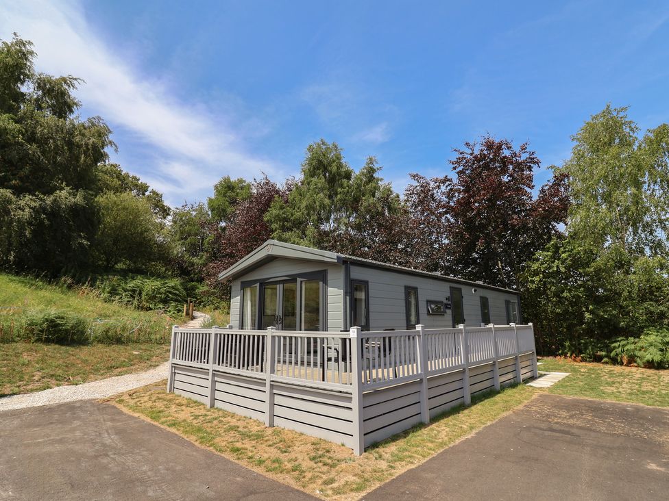A house with decking and trees at The Pines 3 Bedrooms in Delamere