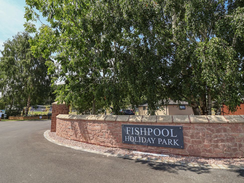A sign for Fishpool Holiday Park at the entrance to the park in Delamere