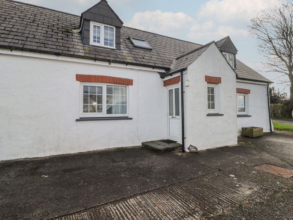 A house with a white exterior and windows at Rhosgranog Cottage Llandeloy near Solva