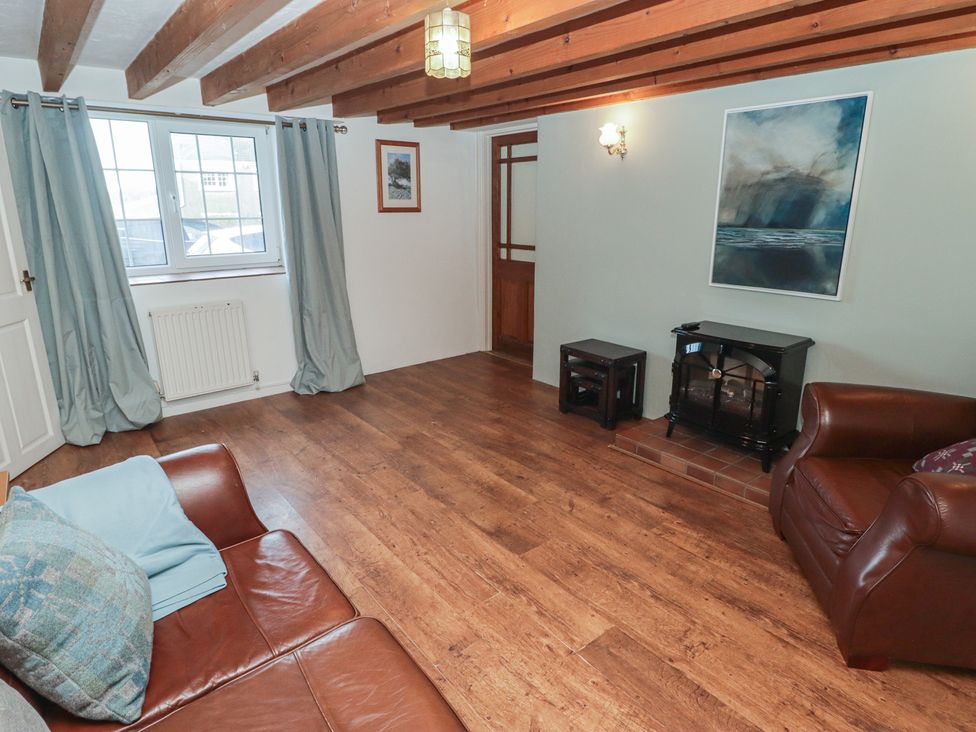 A living room with a sofa and a fireplace at Rhosgranog Cottage in Llandeloy near Solva