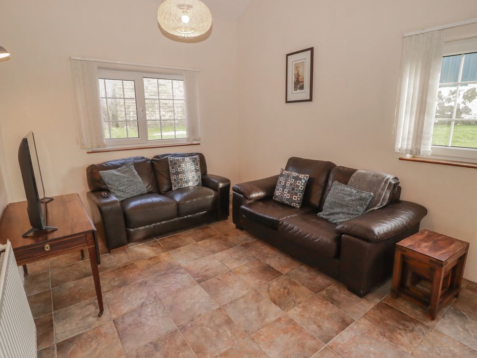 A living room with a television and sofa at Rhosgranog Cottage Llandeloy near Solva