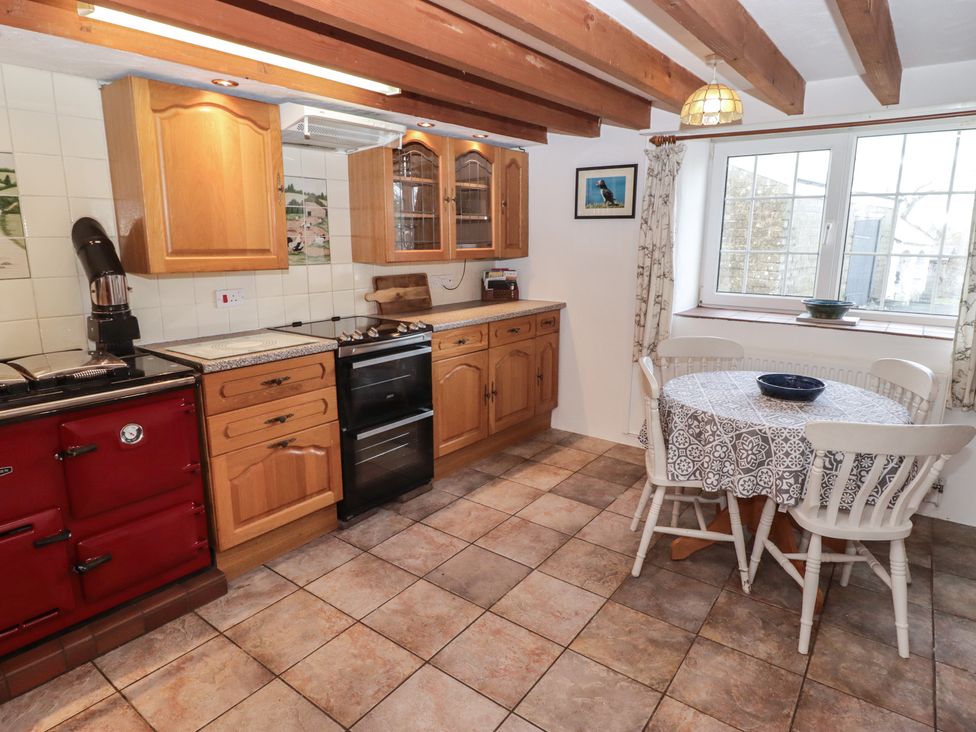A kitchen with cabinets and a table at Rhosgranog Cottage Llandeloy near Solva