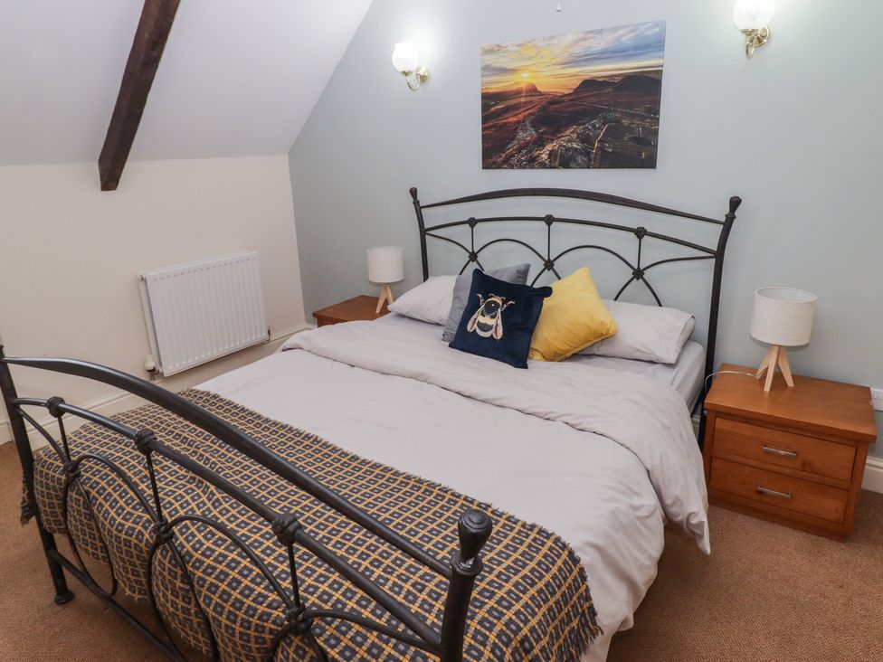 A bedroom with a bed and nightstands at Rhosgranog Cottage, Llandeloy near Solva