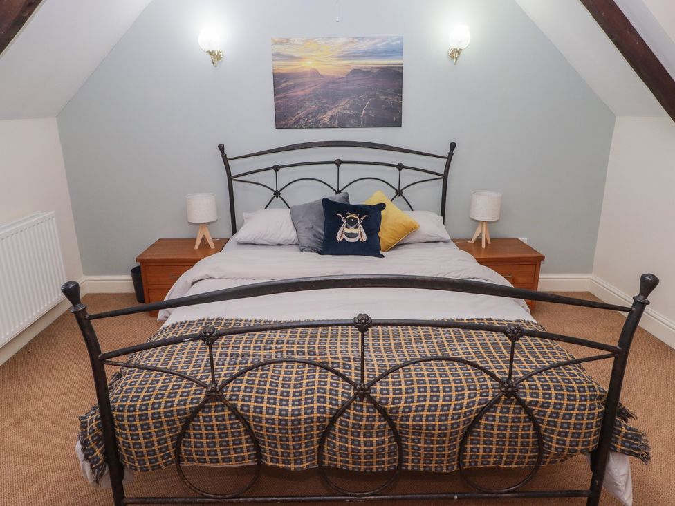 A bedroom with a bed and nightstands at Rhosgranog Cottage Llandeloy near Solva