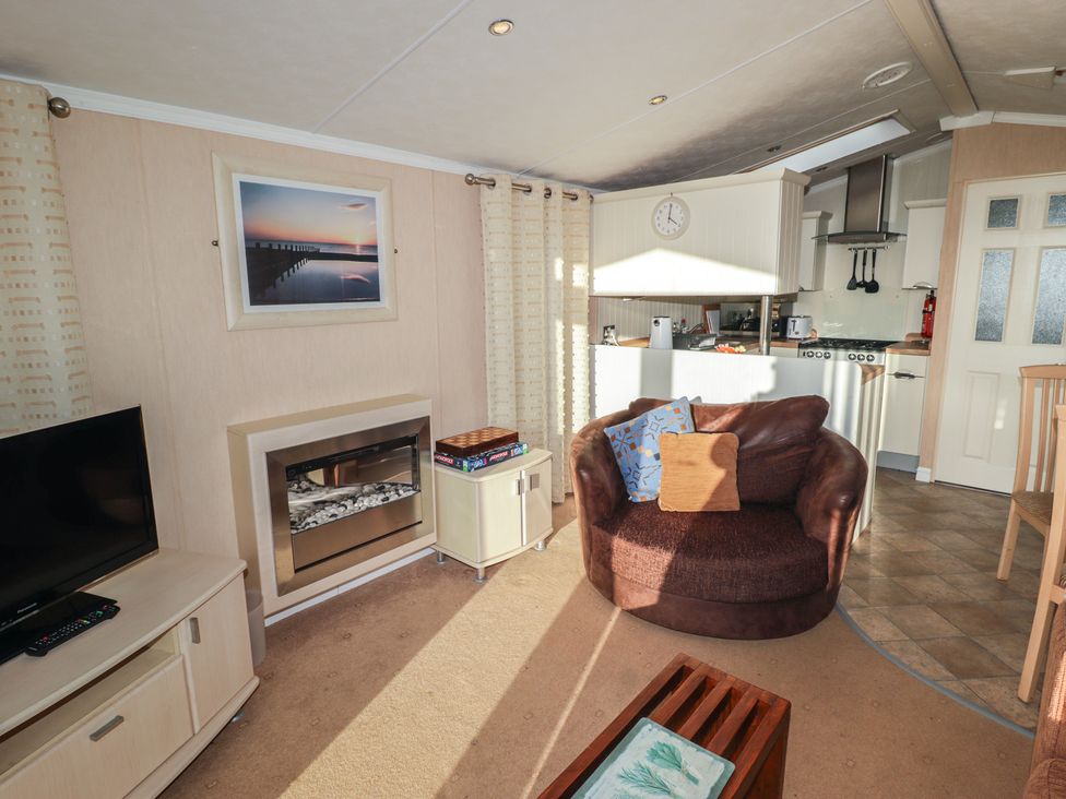 A living room with a television and fireplace at Rhosgranog Caravan Llandeloy near Solva