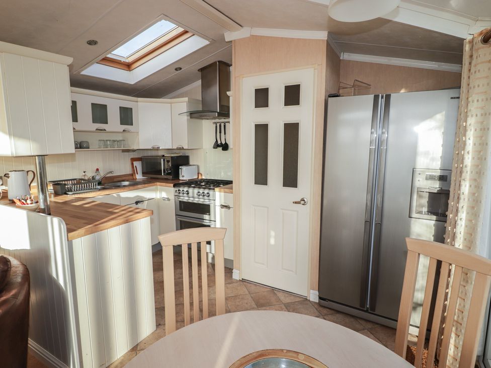 A kitchen with a refrigerator and oven at Rhosgranog Caravan in Llandeloy near Solva
