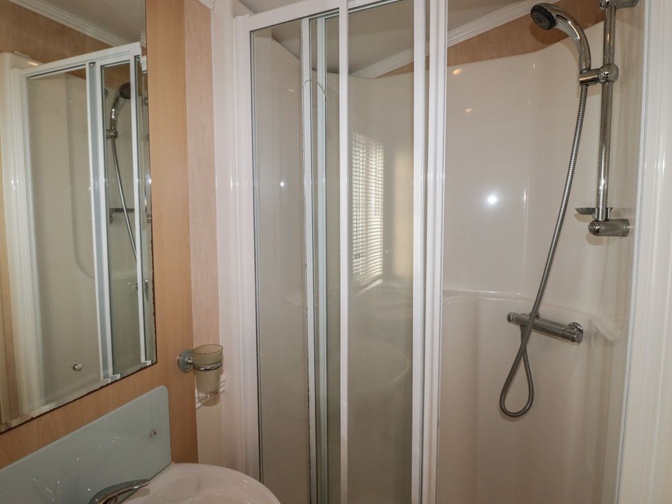 A shower and sink in a bathroom at Rhosgranog Caravan in Llandeloy near Solva