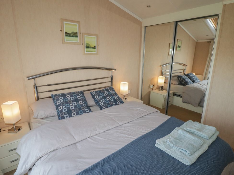 A bedroom with a bed and lamps at Rhosgranog Caravan Llandeloy near Solva