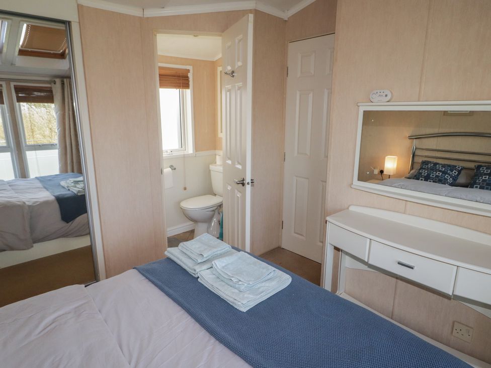 A bathroom with a toilet and mirror at Rhosgranog Caravan Llandeloy near Solva