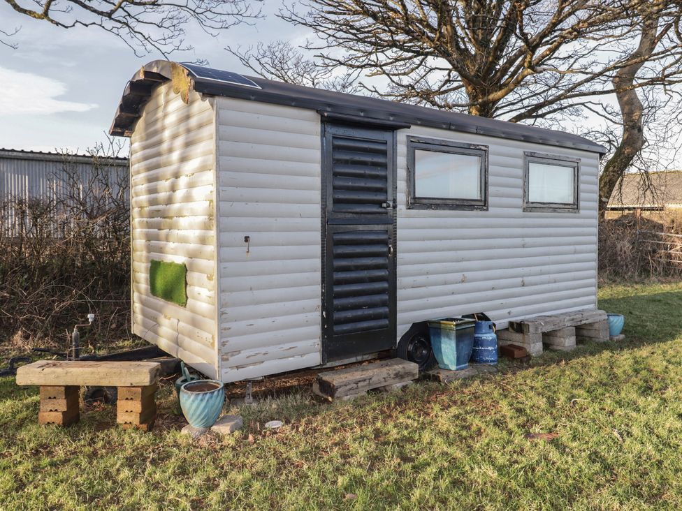 A shepherd's hut with a door and windows at Rhosgranog Shepherds Hut Llandeloy near Solva