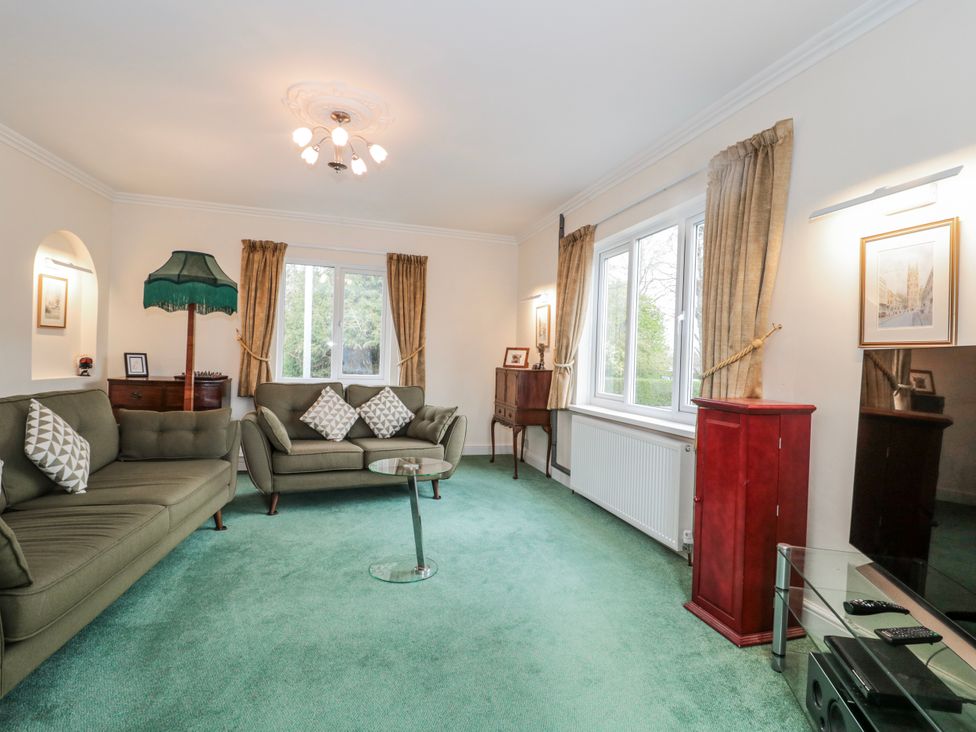 A living room with a sofa, table, and lamp at The Flat House in Taunton
