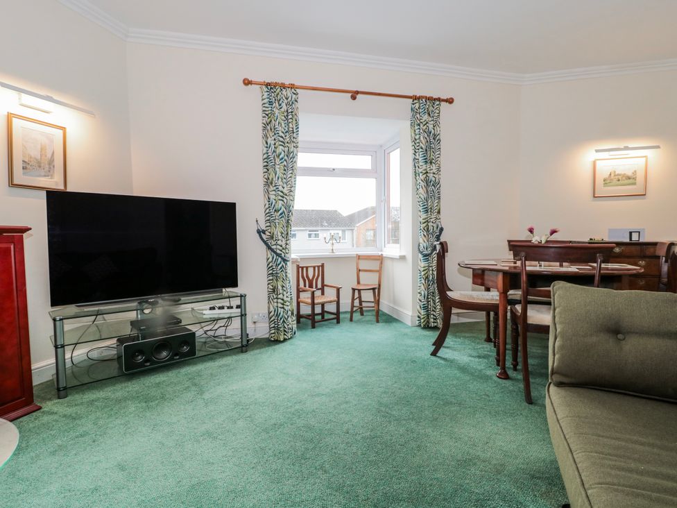 A living room with a television and dining area at The Flat House in Taunton