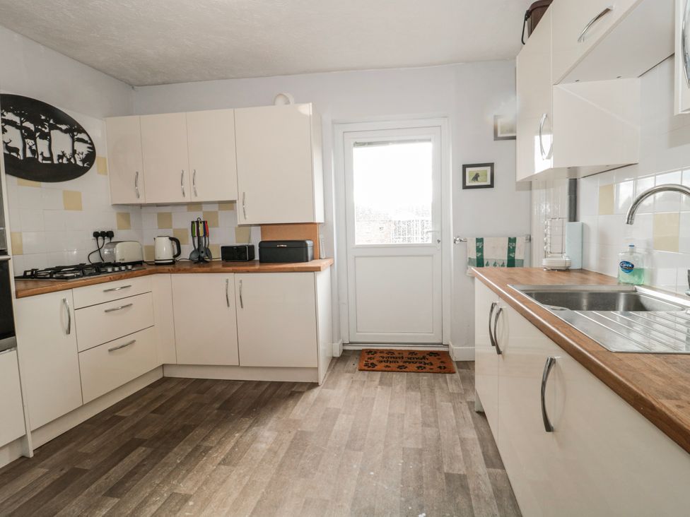 A kitchen with counters and appliances at The Flat House in Taunton