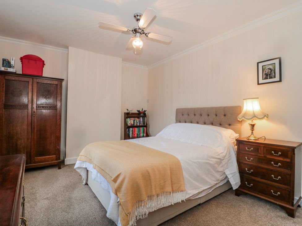A bedroom with a bed, lamp, wardrobe, and bookshelf at The Flat House in Taunton