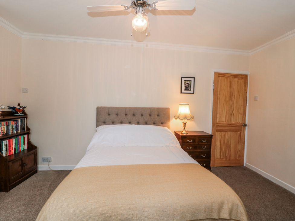 A bedroom with a bed and bookshelf at The Flat House in Taunton