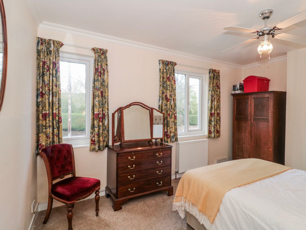 A bedroom with a bed, dresser, and window at The Flat House in Taunton