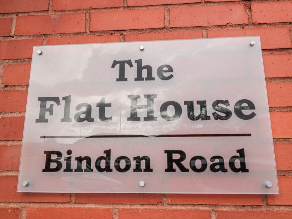 A sign for The Flat House on Bindon Road