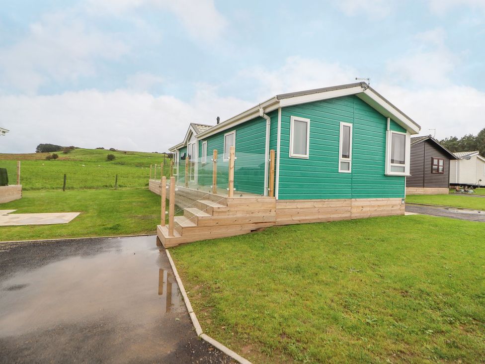A mobile home with decking and steps at No 8 Hillcote Lodge in Cockermouth