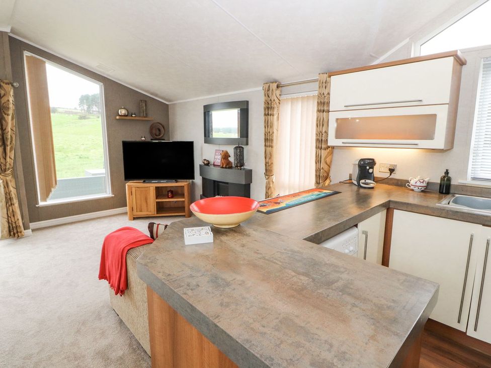 A living room with a sofa and television at No 8 Hillcote Lodge Cockermouth