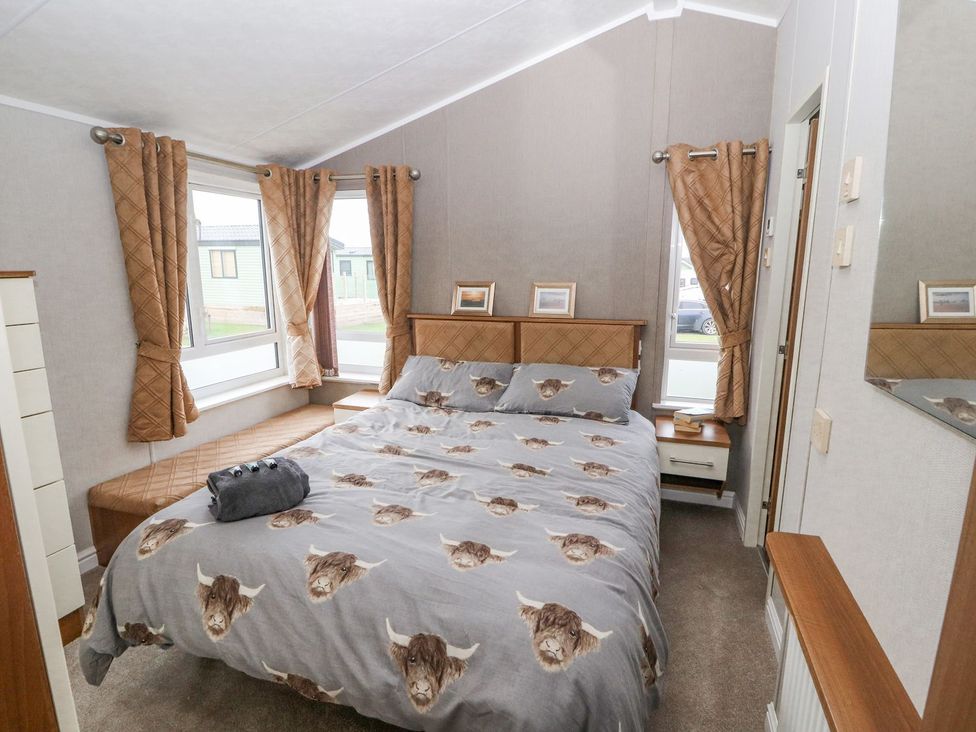 A bedroom with a bed and window at No 8 Hillcote Lodge in Cockermouth